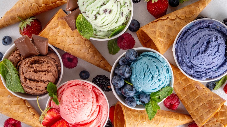 Colorful scoops of ice cream with cones and berries