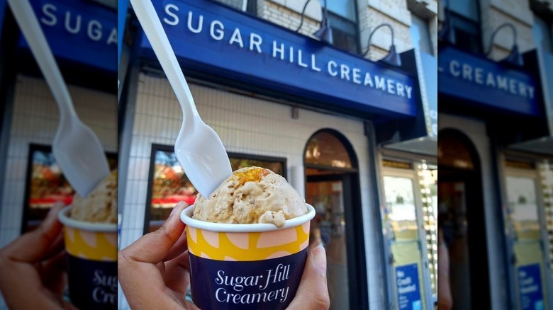 The exterior of Sugar Hill Creamery with a scoop of ice cream held up in front of it