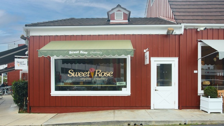 The exterior of Sweet Rose Creamery, it has red walls and a white door