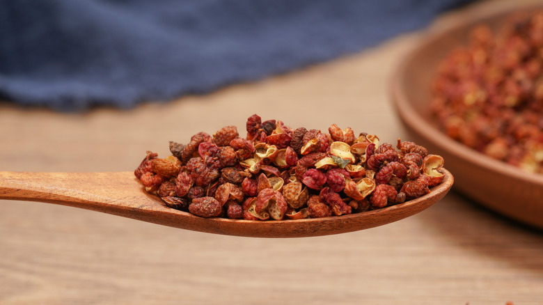 Sun-dried Sichuan peppercorns in a wooden spoon
