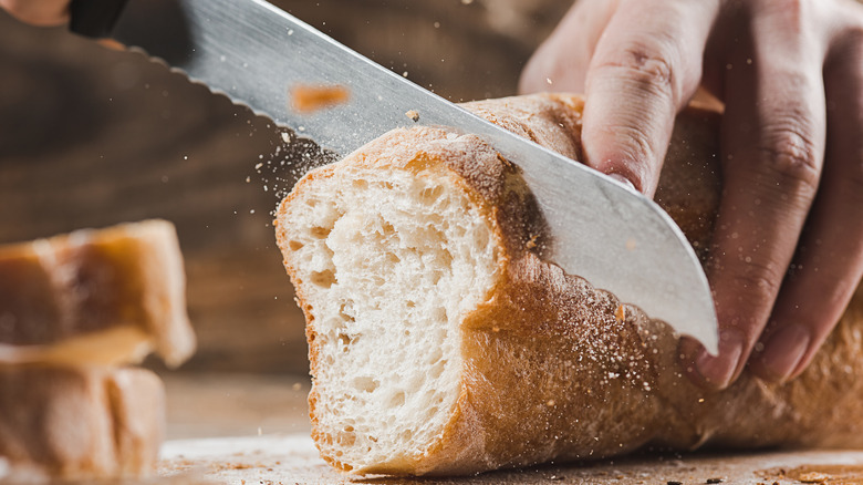 Knife slicing French bread