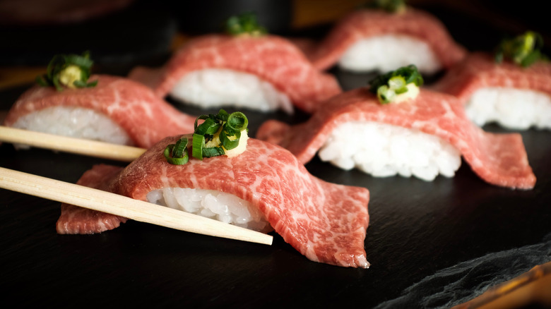 chopsticks grabbing beef nigiri 