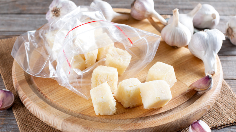 Frozen cubes of crushed garlic on cutting board