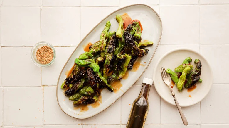 Large dish and plate of grilled shishito peppers