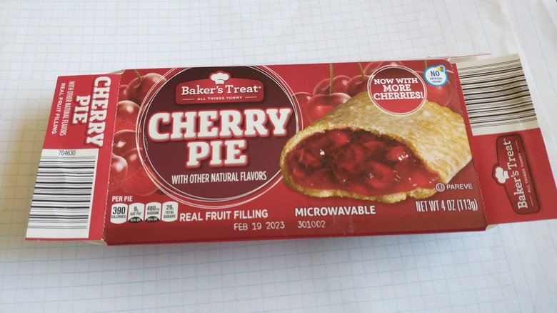 A cherry handpie in a box sits on graph paper
