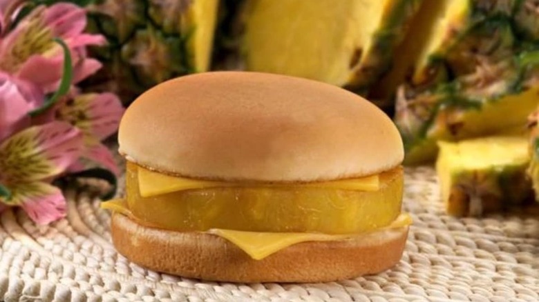 Hula Burger with pineapple and flowers in background
