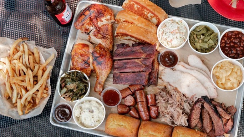 A tray of barbecue: different meats and sides, fries on the side