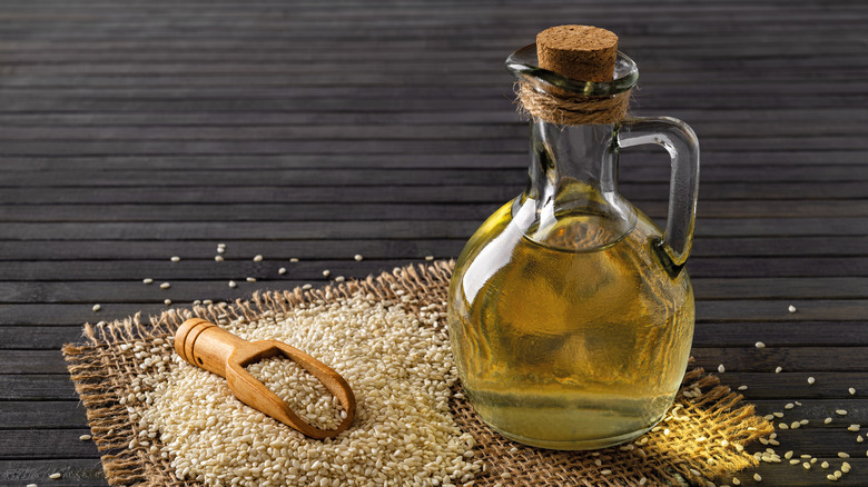 Glass jar of sesame oil with sesame seeds