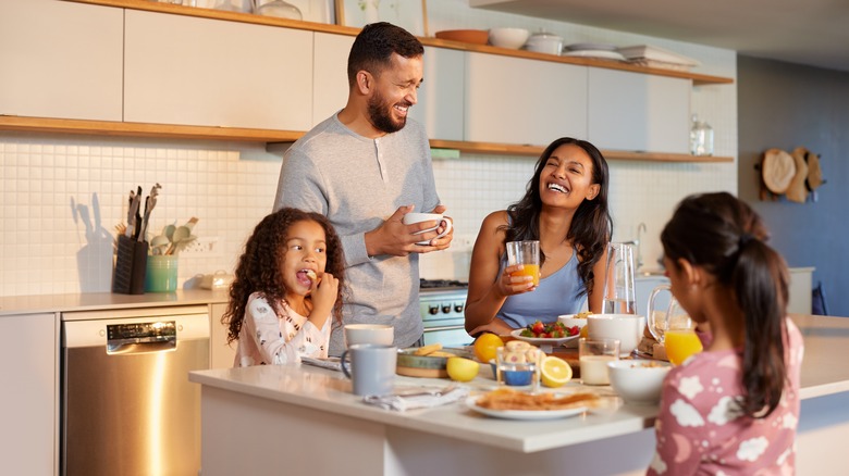 A family of four eating breakfast around a kitchen island