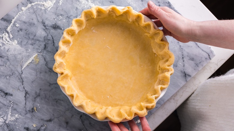 Homemade golden pie crust on marbled surface