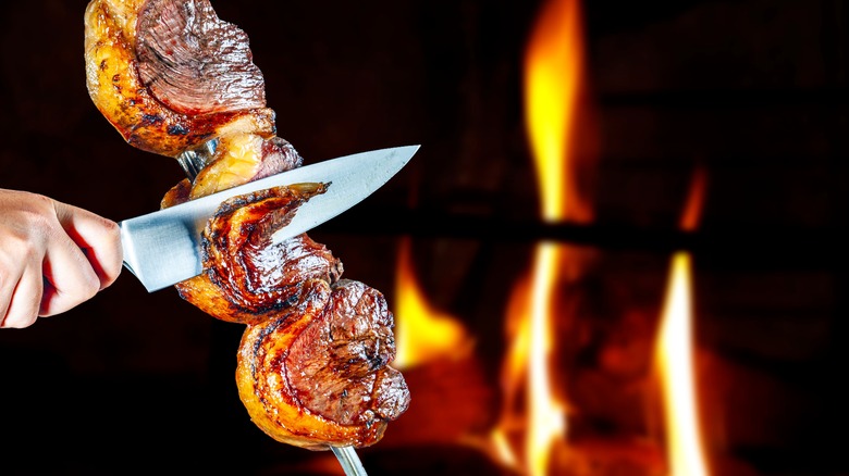 Person slicing picanha with a knife