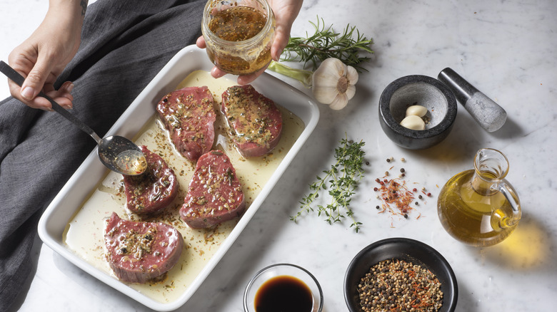 Person marinating meat.