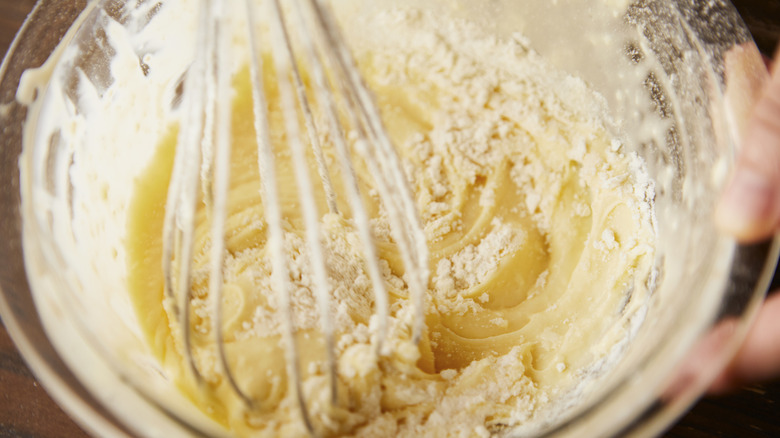 Vanilla boxed cake mix being whisked in glass bowl