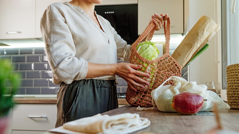 women putting reusable bag on kitchen counter