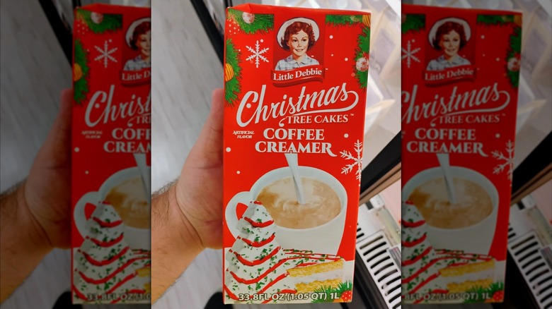 Hand holding Little Debbie Christmas Tree Cakes Coffee Creamer