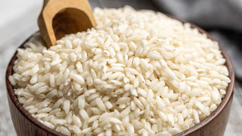Wooden bowl and spoon with raw white rice