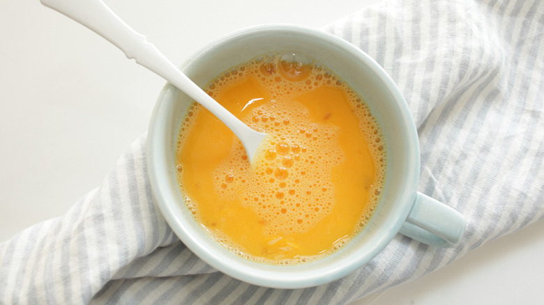 egg wash in mug with fork inside