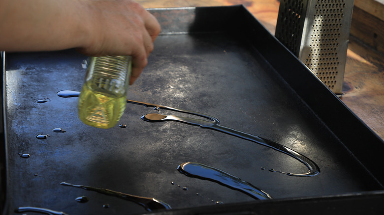 Man pouring oil on griddle