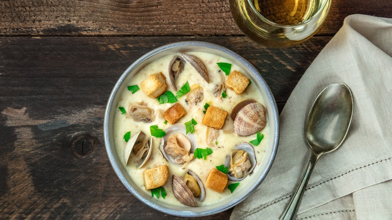 A bowl of clam chowder with mussels, bread crumbs and fresh herbs.