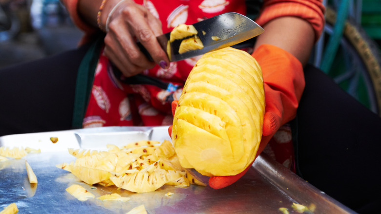 Spiral cutting pineapple with knife