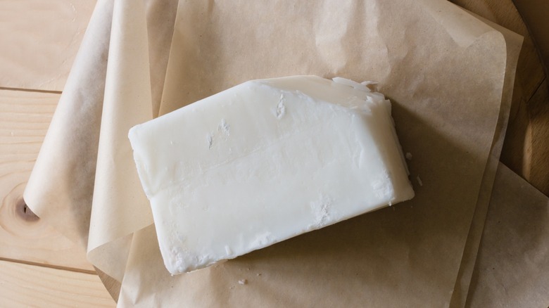 Block of beef tallow on top of sheets of parchment paper