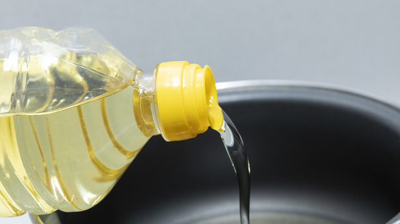 Cooking oil being poured into non-stick pan