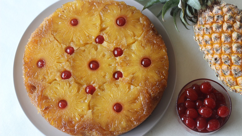 Pineapple upside down cake with maraschino cherries on a plate
