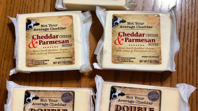 A selection of Aldi cheddar cheeses sit on a wooden table