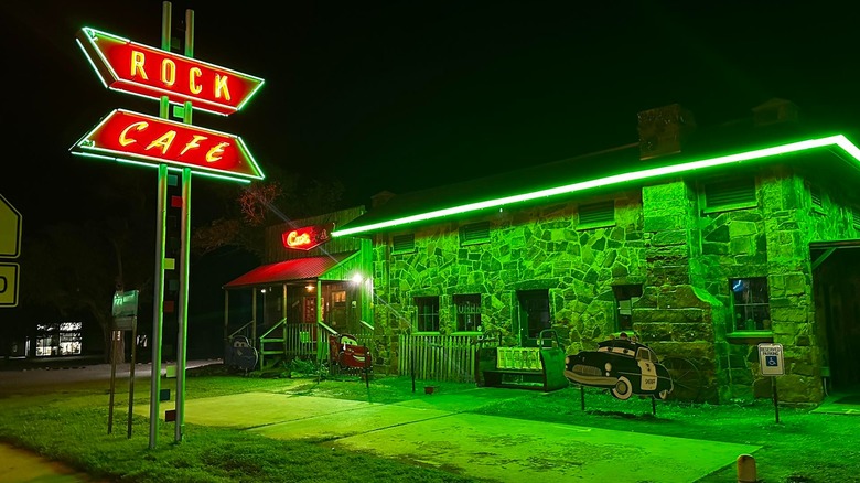 The exterior of Rock Cafe lit up with neon lights