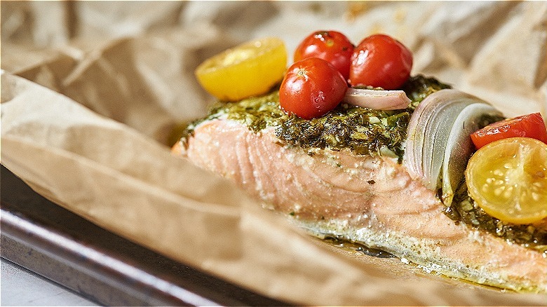 cooked salmon with tomatoes on sheet tray