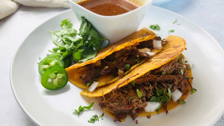 saucy birria tacos on plate