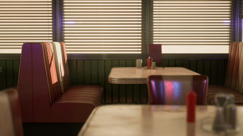 The interior of a diner, red seats and white and chrome tables