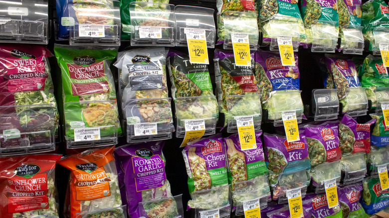 Grocery store refrigeration aisle with plenty of bagged salad kits