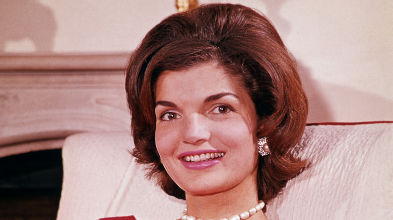Former First Lady Jackie Kennedy smiles as she reclines in her Georgetown home