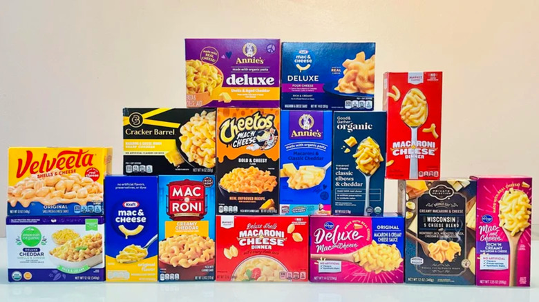 A variety of boxes of store-bought mac and cheese on a white surface.