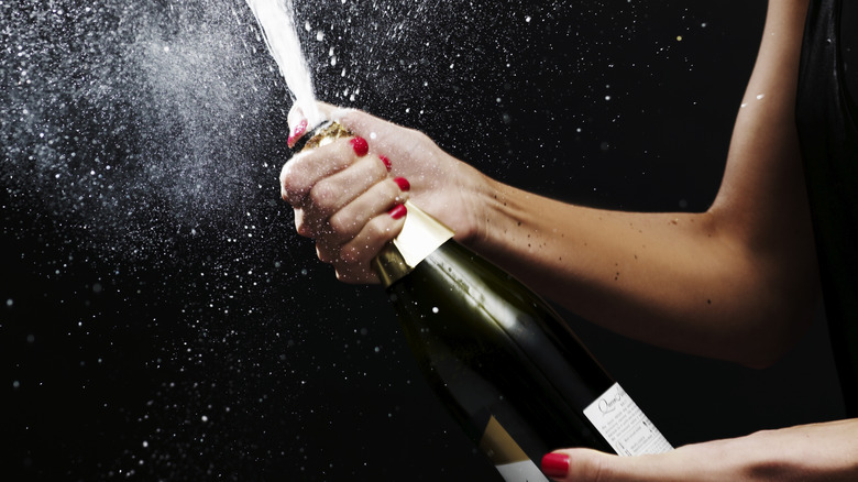 Spraying champagne from a bottle