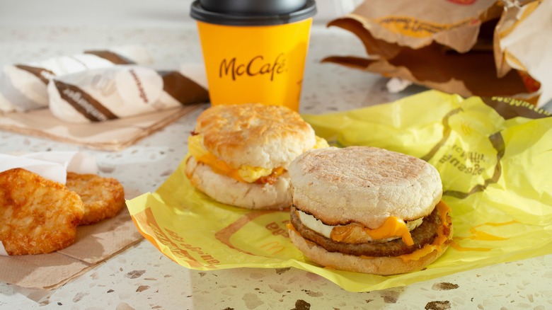A McDonald's breakfast spread, with a sausage mcMuffin, biscuit, hash browns, and a coffee