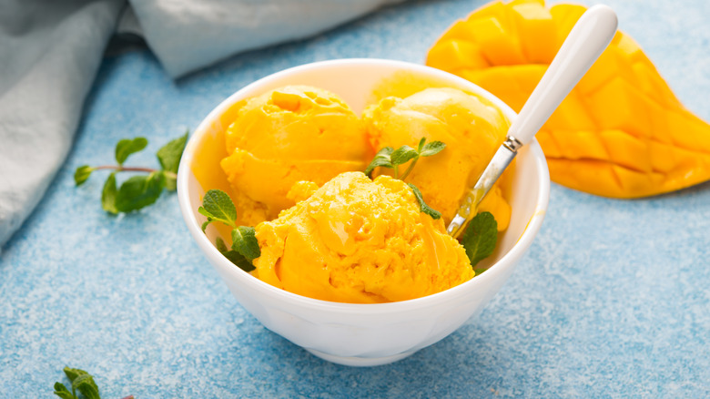 Bowl of creamy mango sherbet garnished with mint