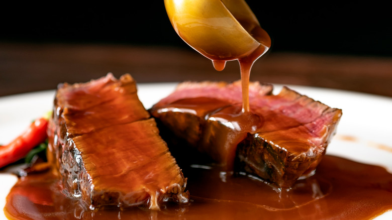 pouring pan sauce over seared steak