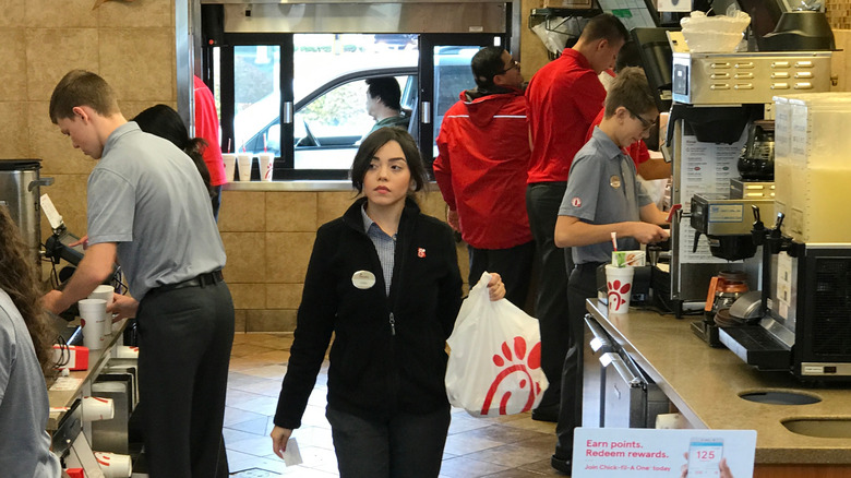 Workers in the kitchen of a busy Chick-Fil-A
