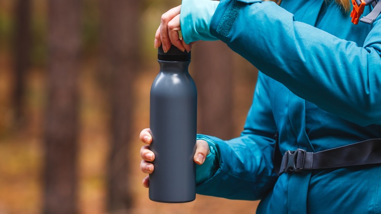 Hiker opening up thermos 