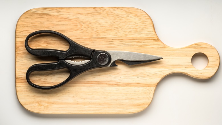 Kitchen shears on wooden cutting board