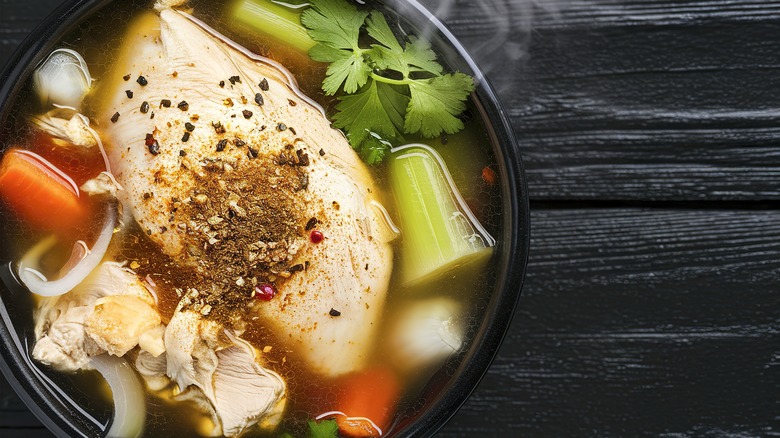 Crowded pot full of chicken soup ingredients