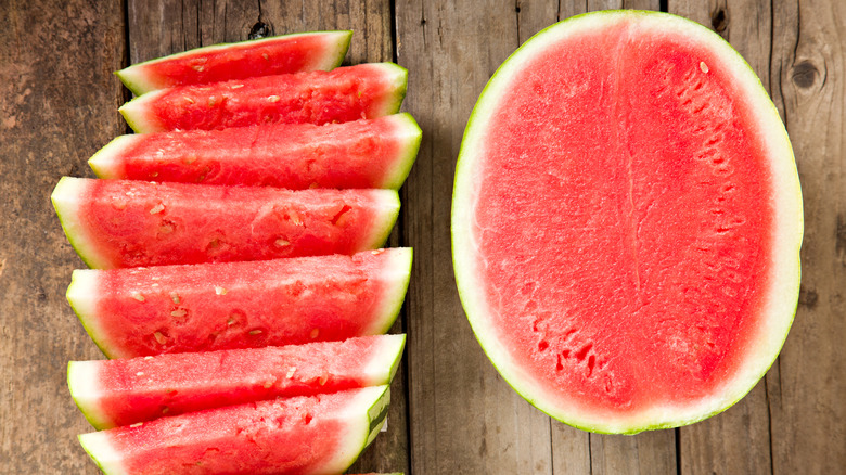 sliced and halved red watermelon on table