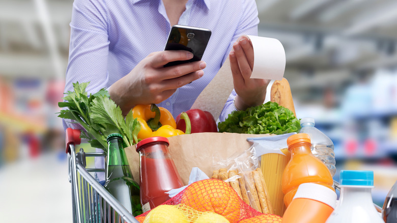Grocery shopper pushing cart with receipt