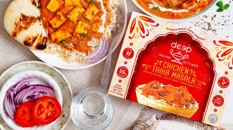 Deep Indian Kitchen Chicken Tikka Masala is plated near its packaging