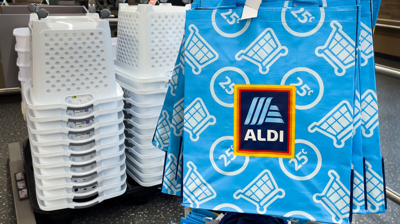 An Aldi shopping bag next to empty store carts