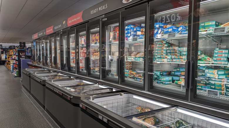 An Aldi freezer cooler sits in the middle of a wide aisle
