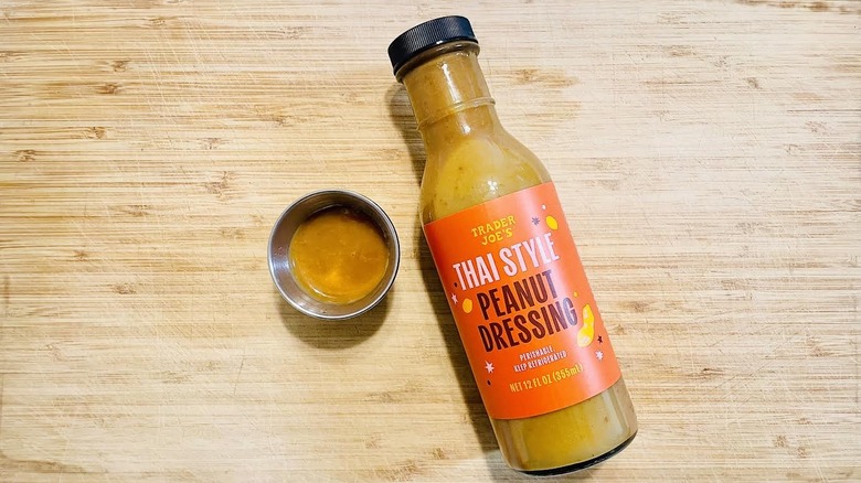 Bottle of Trader Joe's Thai Style Peanut Dressing with ramekin on side