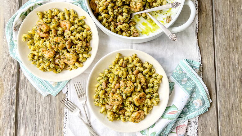 Walnut pesto pasta with shrimp in bowls on table